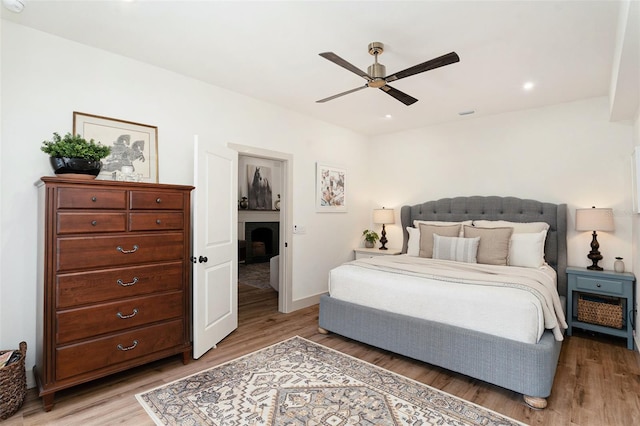 2910 W Aquilla St, Tampa, FL 33629 - bedroom featuring light wood-style floors, a fireplace, baseboards, a ceiling fan, and recessed lighting