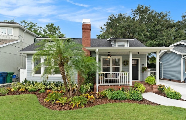 2910 W Aquilla St, Tampa, FL 33629 - view of front of house with covered porch, a ceiling fan, a chimney, a shingled roof, and a front yard