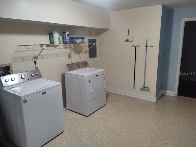 laundry room with electric panel, baseboards, washer and dryer, laundry area, and light floors