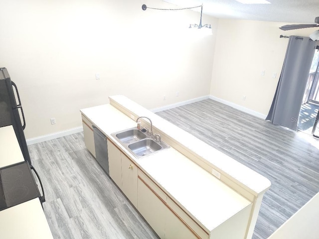kitchen featuring light countertops, a sink, a ceiling fan, stainless steel dishwasher, and light wood-type flooring