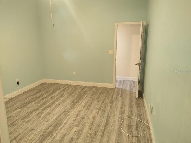 unfurnished room featuring baseboards and light wood-style flooring