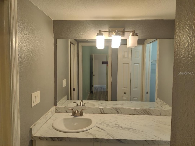 bathroom with vanity and a textured wall