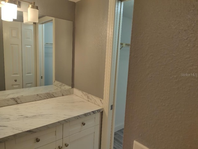 bathroom featuring vanity, a textured wall, and a closet