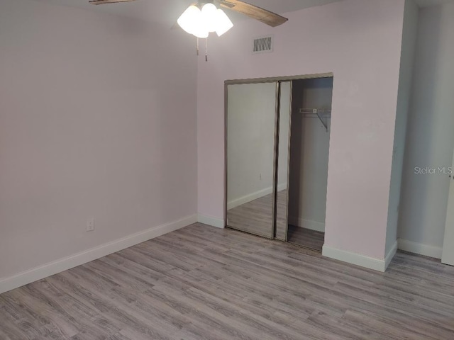 unfurnished bedroom with a closet, baseboards, and wood finished floors