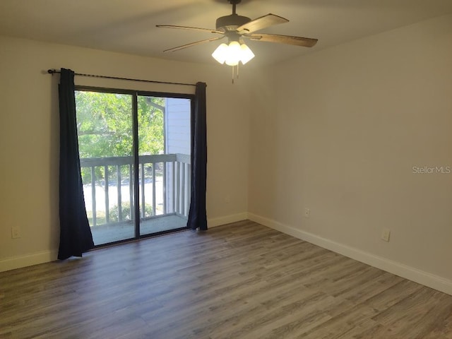 spare room with baseboards, ceiling fan, and wood finished floors