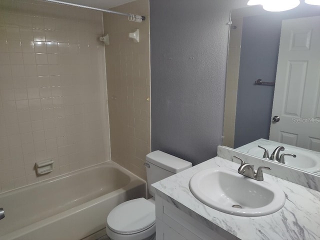 full bath featuring toilet, vanity, a textured wall, and shower / bathtub combination