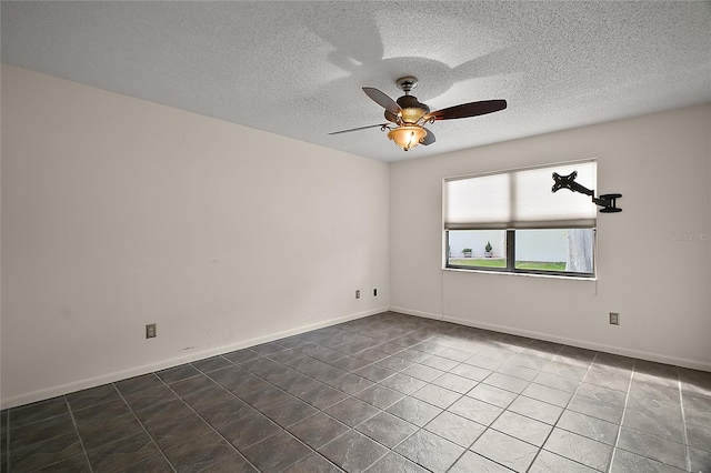 tiled empty room featuring baseboards, a ceiling fan, and a textured ceiling