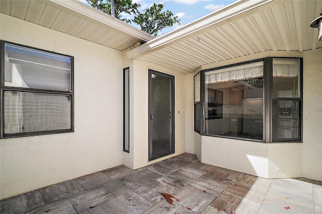 entrance to property featuring stucco siding