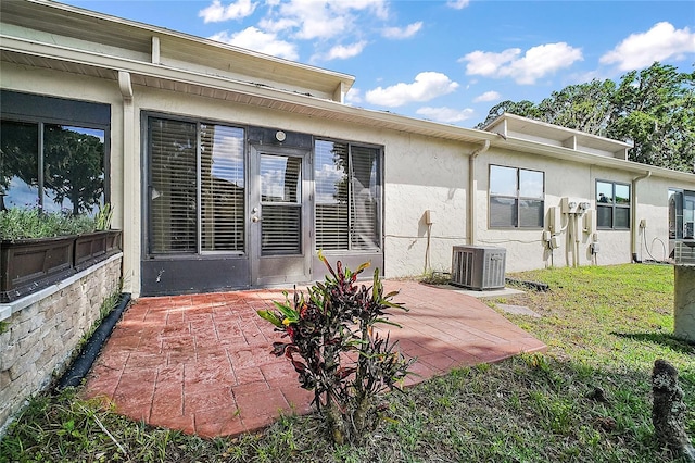 back of house with a yard, a patio, central AC, and stucco siding