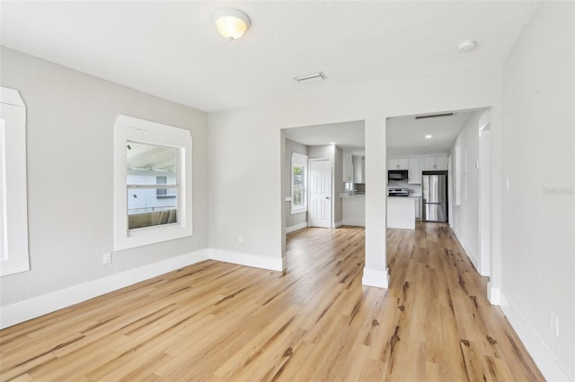 2920 E 20th Ave, Tampa, FL 33605 - unfurnished living room with baseboards, visible vents, and light wood-style floors