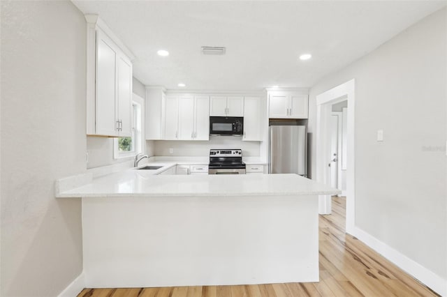 2920 E 20th Ave, Tampa, FL 33605 - kitchen with light countertops, a sink, appliances with stainless steel finishes, a peninsula, and visible vents