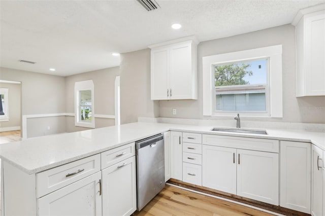 2920 E 20th Ave, Tampa, FL 33605 - kitchen with stainless steel dishwasher, a sink, visible vents, white cabinets, and a peninsula