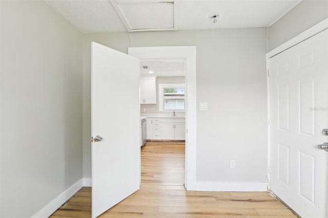 2920 E 20th Ave, Tampa, FL 33605 - corridor with baseboards, light wood-type flooring, and a sink