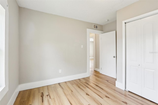 2920 E 20th Ave, Tampa, FL 33605 - unfurnished bedroom with baseboards, visible vents, a closet, and wood finished floors