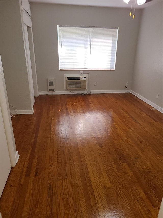 548 3rd St N, Saint Petersburg, FL 33701 - spare room featuring a wall mounted AC, baseboards, heating unit, and wood finished floors
