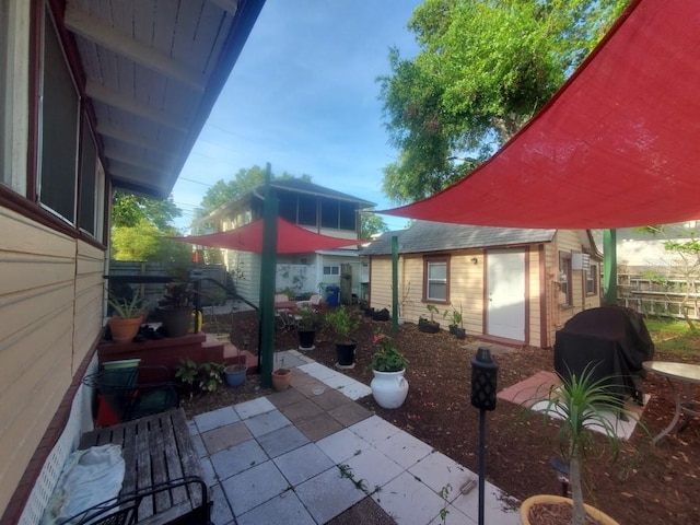 548 3rd St N, Saint Petersburg, FL 33701 - view of patio with an outdoor structure, fence, and a grill