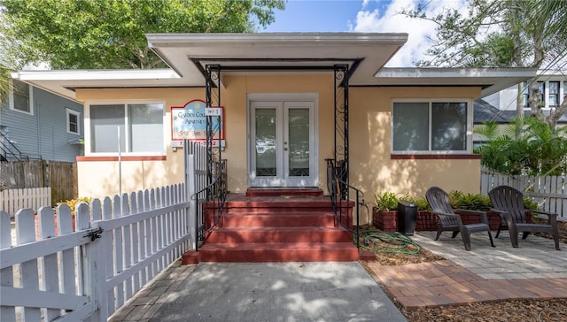 548 3rd St N, Saint Petersburg, FL 33701 - entrance to property featuring a patio area, french doors, fence, and stucco siding