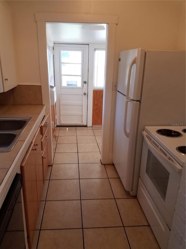 548 3rd St N, Saint Petersburg, FL 33701 - kitchen with light tile patterned floors, dishwashing machine, white range with electric stovetop, a sink, and tile counters
