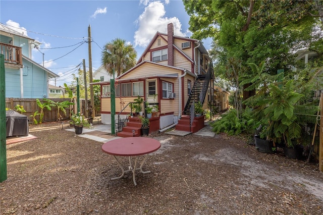 548 3rd St N, Saint Petersburg, FL 33701 - back of property featuring cooling unit, a chimney, fence, and stairway