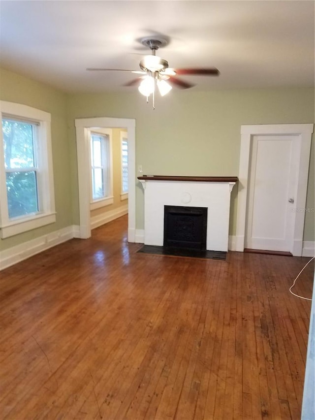 548 3rd St N, Saint Petersburg, FL 33701 - unfurnished living room with ceiling fan, hardwood / wood-style floors, a fireplace with flush hearth, and baseboards