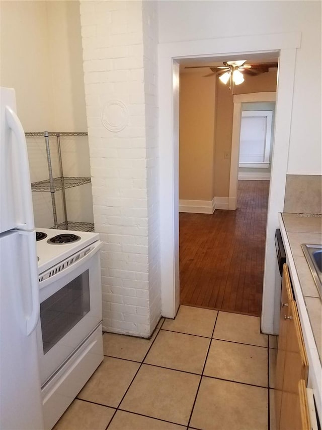 548 3rd St N, Saint Petersburg, FL 33701 - kitchen featuring light tile patterned floors, ceiling fan, light countertops, white appliances, and white cabinetry