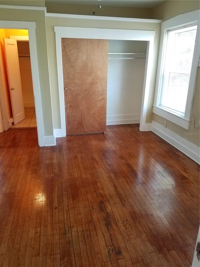 548 3rd St N, Saint Petersburg, FL 33701 - unfurnished bedroom with a closet, baseboards, and hardwood / wood-style flooring
