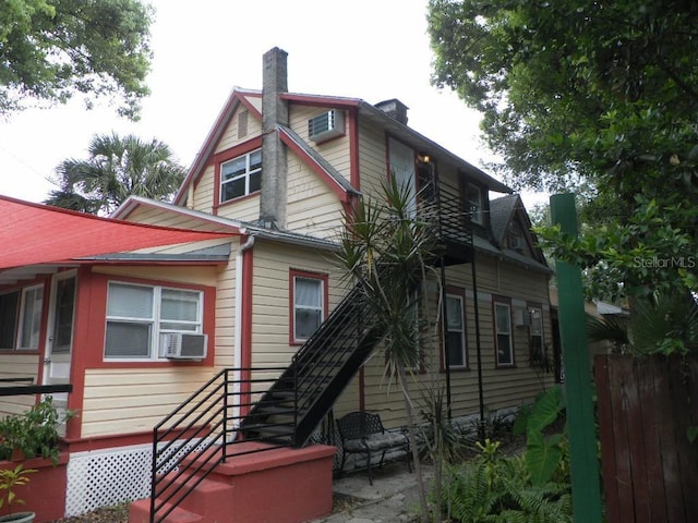 548 3rd St N, Saint Petersburg, FL 33701 - back of house featuring fence, cooling unit, and a chimney