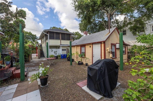 548 3rd St N, Saint Petersburg, FL 33701 - rear view of property featuring stairway, a sunroom, and an outbuilding