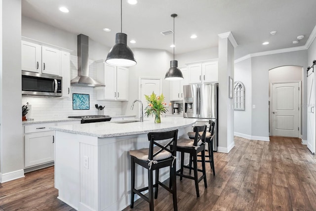 14241 Natures Reserve Dr, Lithia, FL 33547 - kitchen with appliances with stainless steel finishes, wall chimney range hood, a kitchen island with sink, white cabinetry, and backsplash