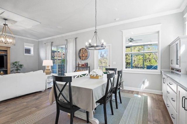 14241 Natures Reserve Dr, Lithia, FL 33547 - dining space with a chandelier, dark wood finished floors, ornamental molding, ceiling fan, and baseboards