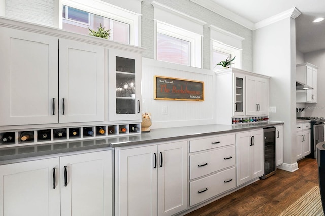 14241 Natures Reserve Dr, Lithia, FL 33547 - kitchen featuring beverage cooler, dark wood finished floors, stainless steel range with gas stovetop, ornamental molding, and glass insert cabinets