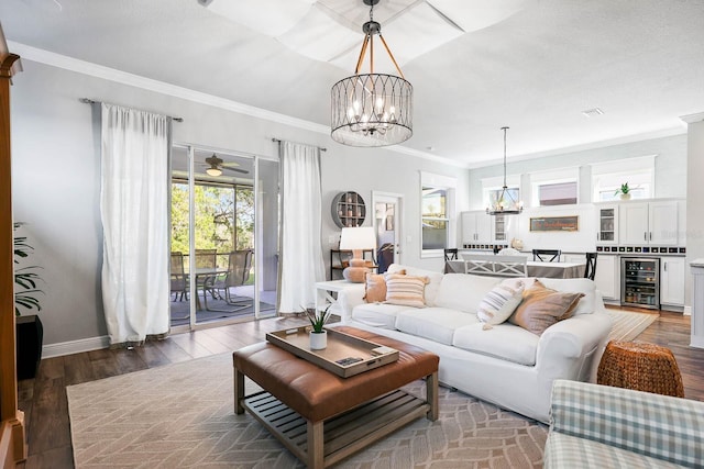 14241 Natures Reserve Dr, Lithia, FL 33547 - living area featuring a chandelier, beverage cooler, ornamental molding, wood finished floors, and ceiling fan