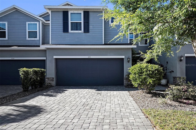 1110 Rose Blossom Ct, Tampa, FL 33613 - view of front of house with decorative driveway, a garage, and stone siding