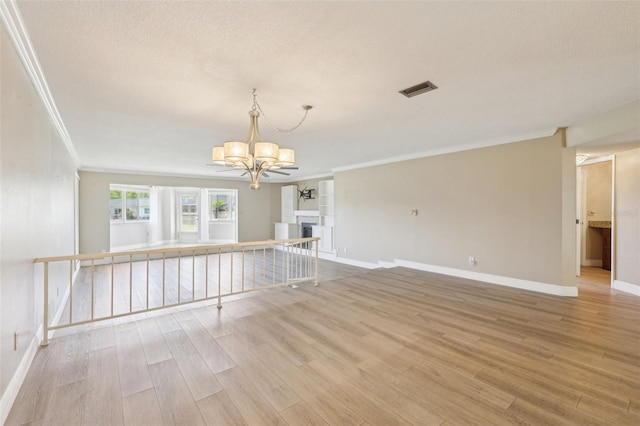3252 Scorecard Dr, New Port Richey, FL 34655 - spare room featuring wood finished floors, ornamental molding, and an inviting chandelier
