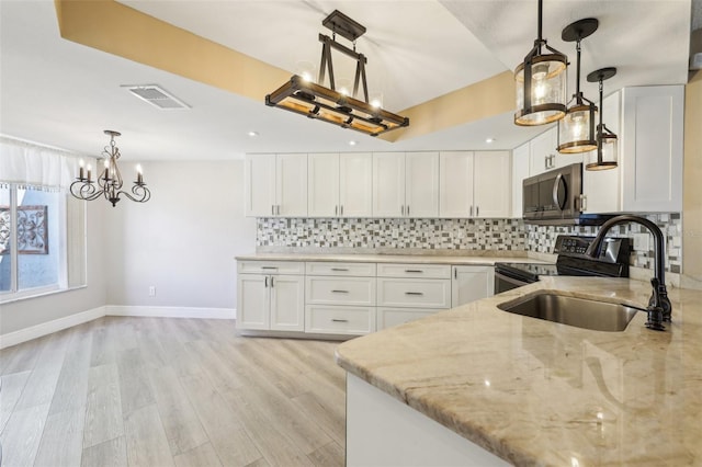 3252 Scorecard Dr, New Port Richey, FL 34655 - kitchen featuring white cabinets, stainless steel appliances, visible vents, a chandelier, and light stone countertops