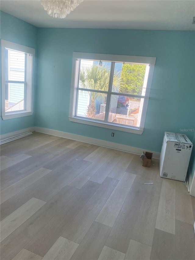 27 Kingfish St, Santa Rosa Beach, FL 32459 - unfurnished room featuring baseboards, wood finished floors, and an inviting chandelier