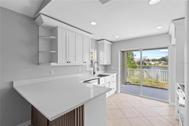 10108 36th Ct E, Parrish, FL 34219 - kitchen with a peninsula, open shelves, white cabinetry, a water view, and recessed lighting