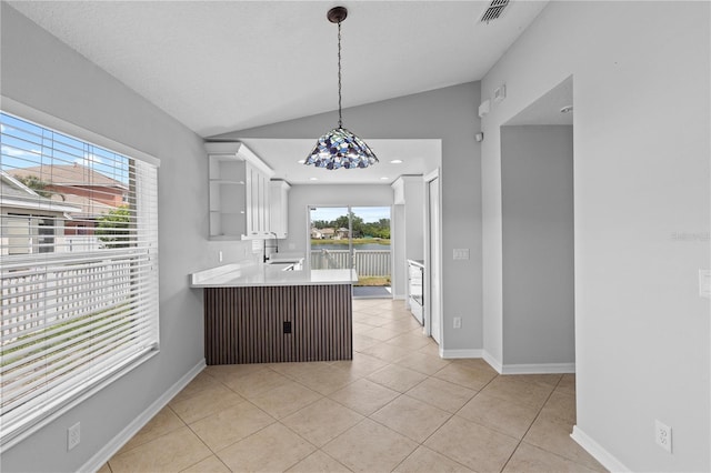 10108 36th Ct E, Parrish, FL 34219 - kitchen with vaulted ceiling, open shelves, white cabinets, light countertops, and light tile patterned floors