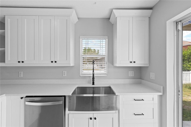 10108 36th Ct E, Parrish, FL 34219 - kitchen featuring stainless steel dishwasher, light countertops, healthy amount of natural light, and white cabinetry