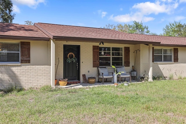 9825 Casey Dr, New Port Richey, FL 34654 - view of front facade with brick siding, a front yard, and roof with shingles