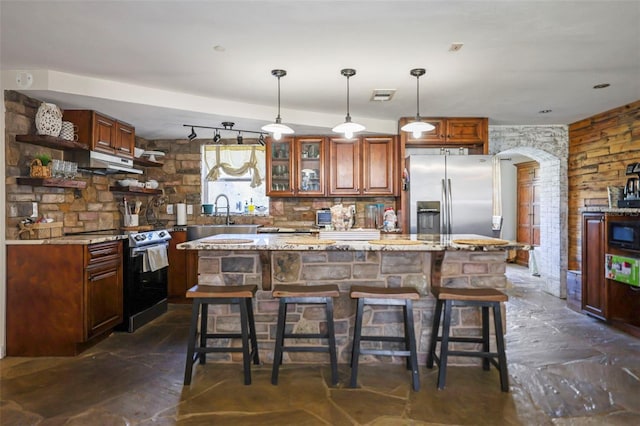 9825 Casey Dr, New Port Richey, FL 34654 - kitchen with visible vents, under cabinet range hood, a sink, stainless steel fridge with ice dispenser, and range with electric stovetop