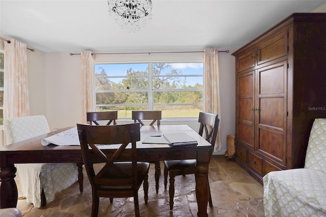 9825 Casey Dr, New Port Richey, FL 34654 - dining room with stone finish flooring and an inviting chandelier