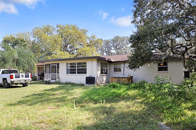 9825 Casey Dr, New Port Richey, FL 34654 - view of front of house with stucco siding, a front yard, and central air condition unit
