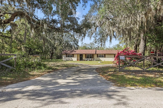 9825 Casey Dr, New Port Richey, FL 34654 - view of front of house featuring driveway, stucco siding, and fence
