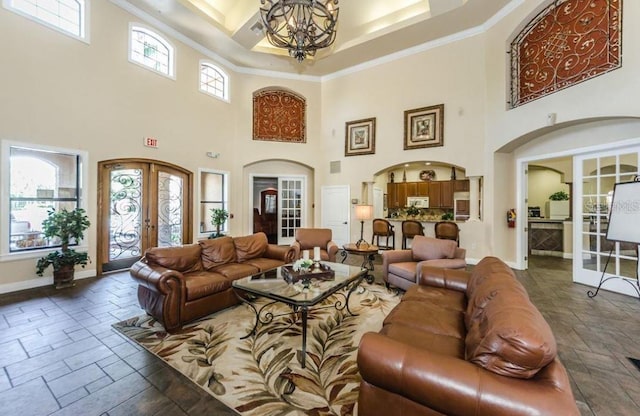 2220 Chianti Pl Unit 8-0817, Palm Harbor, FL 34683 - living area featuring a high ceiling, stone tile flooring, a chandelier, baseboards, and french doors