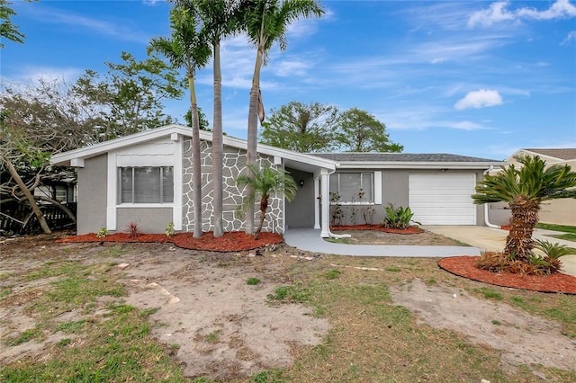 view of front of property featuring a garage, concrete driveway, and stucco siding