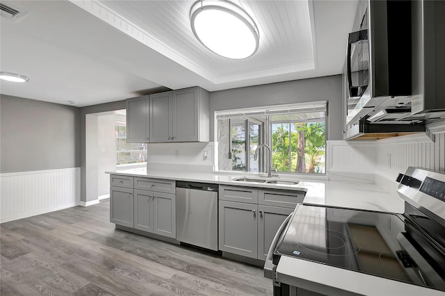 kitchen with gray cabinets, a sink, appliances with stainless steel finishes, and visible vents