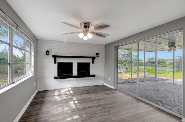 unfurnished living room featuring baseboards, wood finished floors, and a ceiling fan