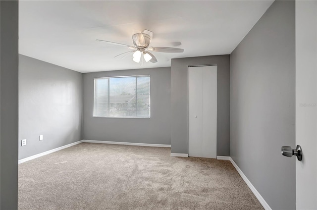 spare room featuring baseboards, carpet flooring, and ceiling fan