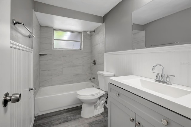 full bathroom featuring bathtub / shower combination, wood finished floors, toilet, vanity, and wainscoting